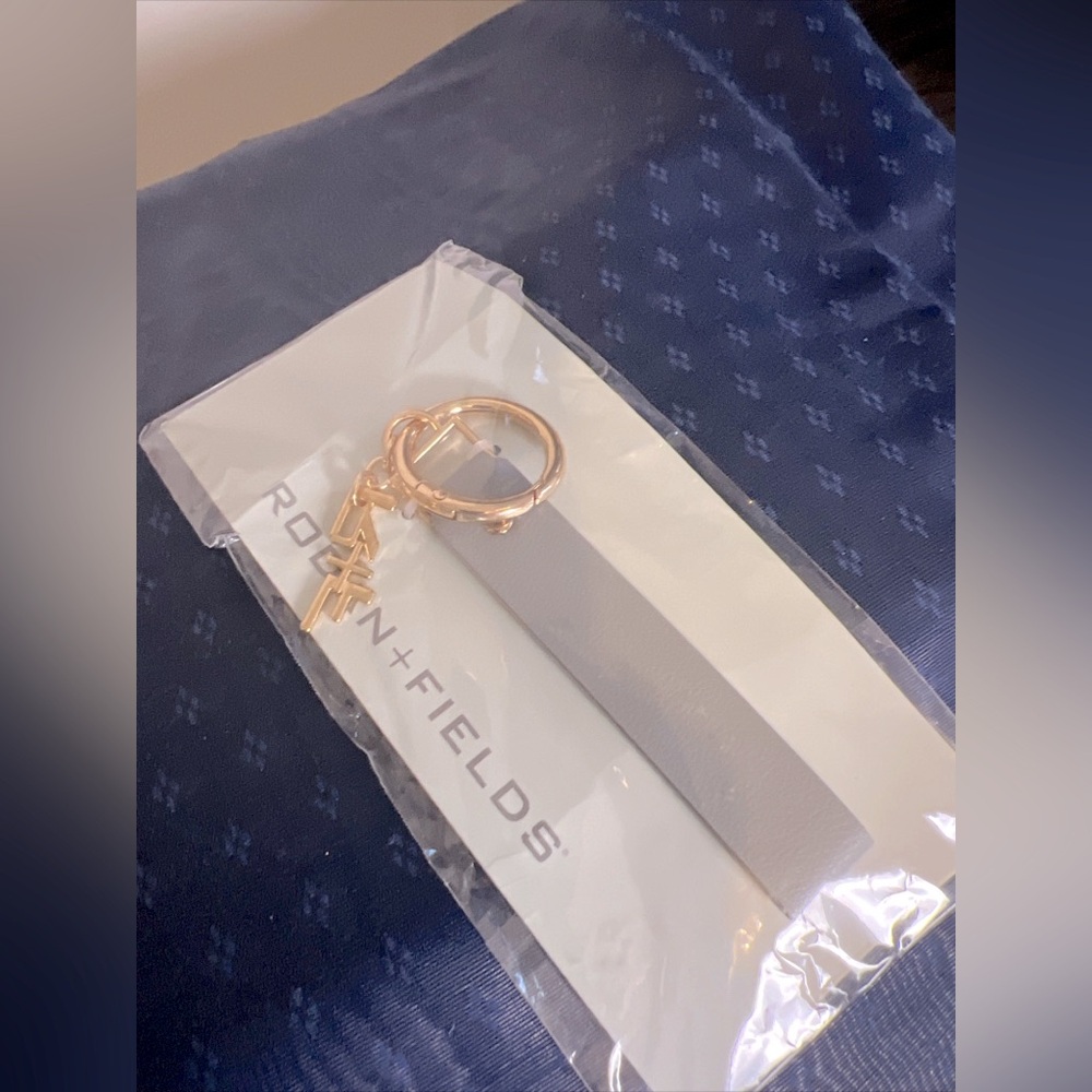 Rodan and Fields gray leatherette & gold metal signature R&F charm key chain